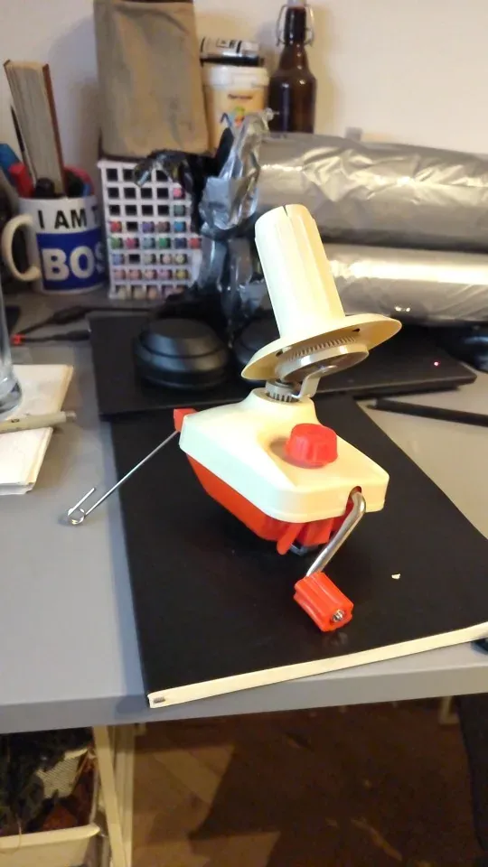 Ball winder set up on a work desk with the yarn guide raised, photo from a verified buyer